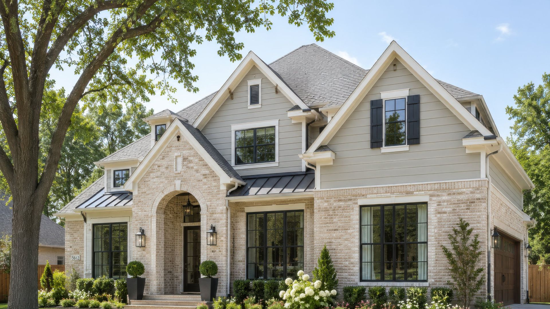 A two-story home with fiber cement lap siding, brick, and white trim